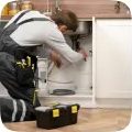 Plumber working under a kitchen sink