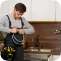 Plumber fitting a hose in a kitchen